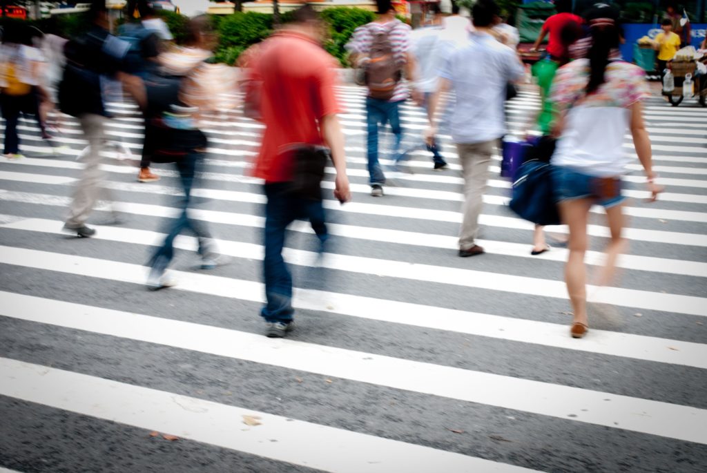 Crosswalk with lots of people crossing the street where they could get injured.