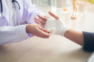 A man getting his wrist bandaged following an auto accident with a motor vehicle