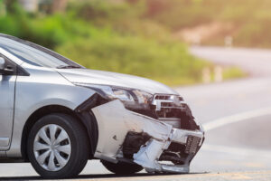 Front of silver car get damaged by crash accident on the road. Car repair or car insurance concept