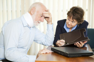 Injured senior man and his personal injury lawyer worrying about the cost of medical bills.