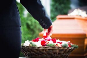 a basket of flowers next to a coffin