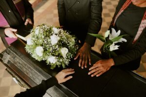 people surrounding a coffin